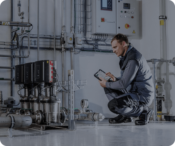 A technician in a factory looking at a tablet