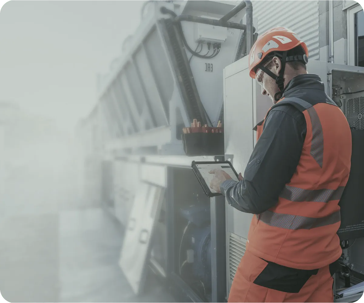 A technician next to a electric box looking at a tablet