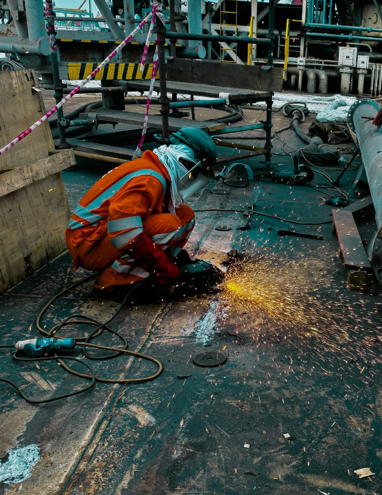 Maintenance technician grinding on an oil rig