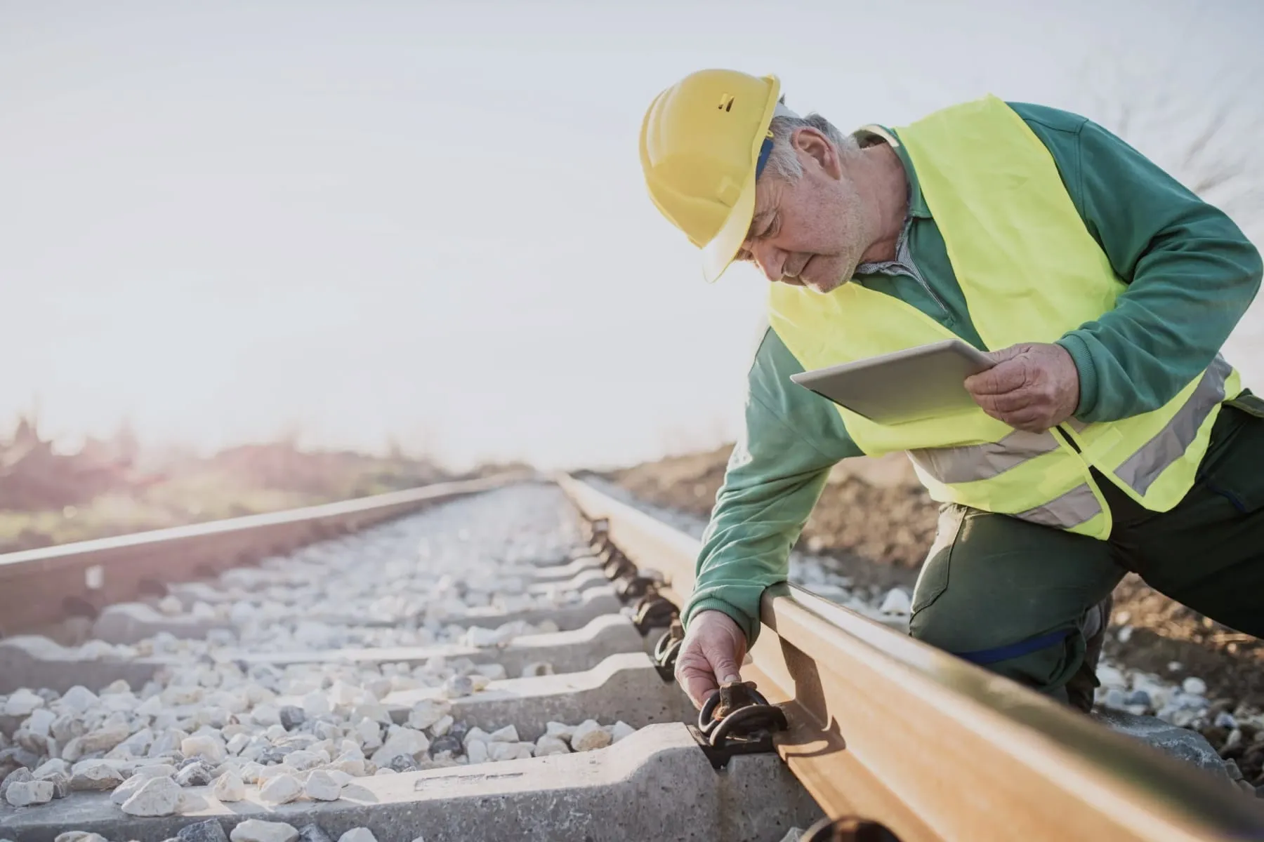 Field service technician with a tablet inspecting rail tracks