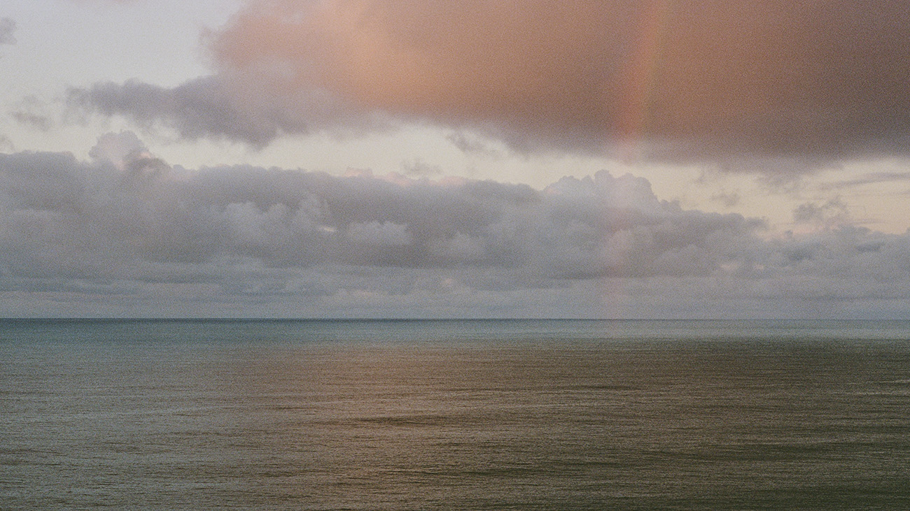 Traveler reaching out over the ocean, water streaming from their hand