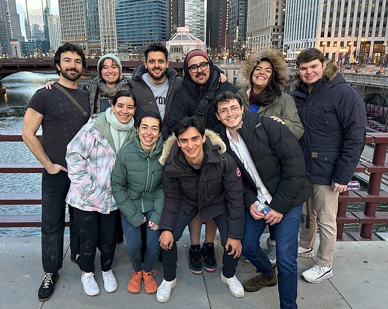 Beyond Team smiling and posing together on a city bridge in Chicago.