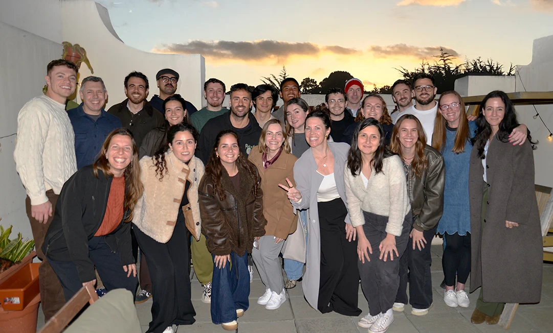 Beyond Team smiling and posing outdoors during sunset on a patio.