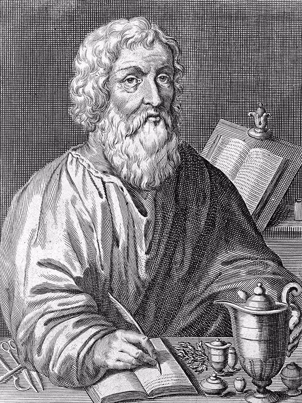 Incisione in bianco e nero di un uomo barbuto con capelli ricci che scrive su un libro con una penna, circondato da un vaso, un calice e un libro aperto sullo sfondo.