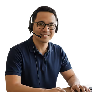 Smiling man wearing glasses and a headset, seated at a desk.