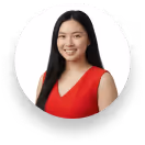 Smiling woman with long black hair wearing a red sleeveless top against a white background.