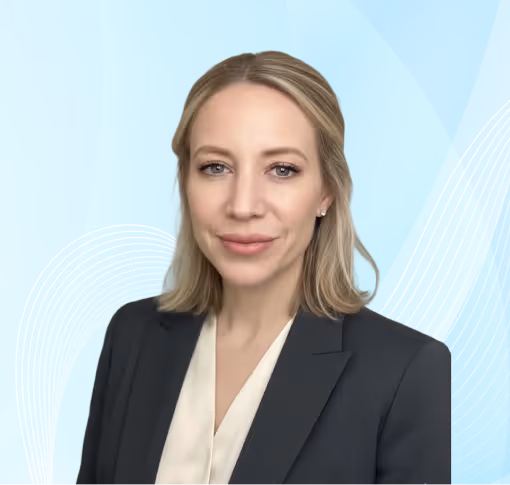 Professional headshot of a blonde woman wearing a dark blazer and cream blouse against a blue background with white wave patterns.