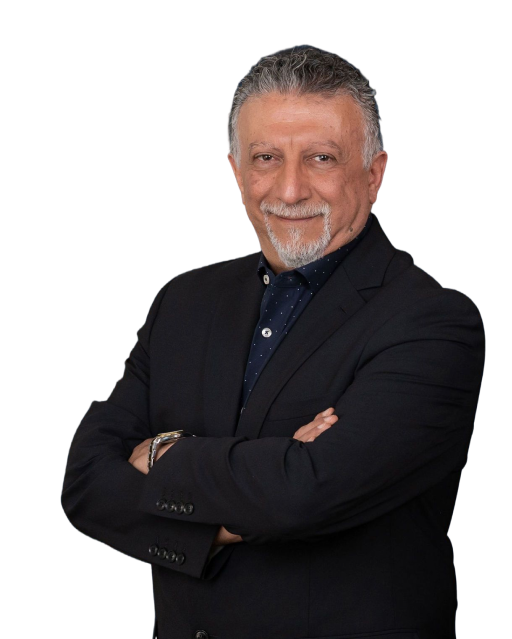 Smiling middle-aged man with gray hair and beard wearing a dark suit jacket and crossing his arms.