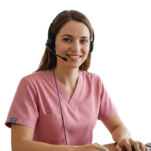 Smiling woman in pink medical scrubs wearing a headset seated at a desk.