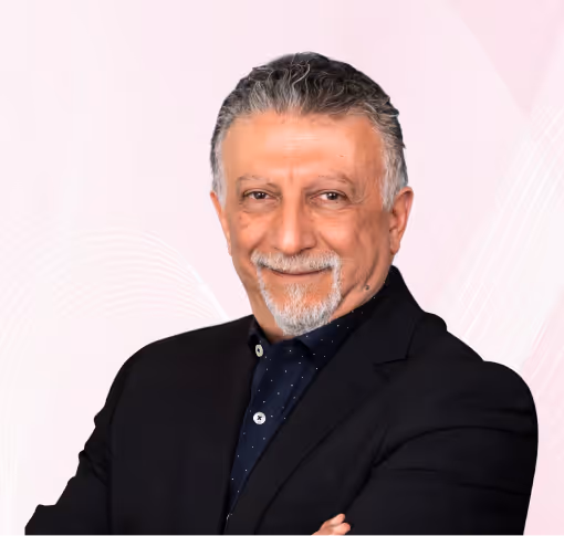 Smiling middle-aged man with gray hair and goatee wearing a dark suit, standing with arms crossed against a blue abstract background.