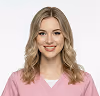 Smiling woman with brown hair wearing a pink shirt and white undershirt.