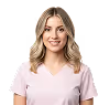 Smiling young woman with blonde hair wearing a light pink shirt against white background.