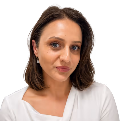 Woman with shoulder-length brown hair wearing a white top and small earrings, looking at the camera.