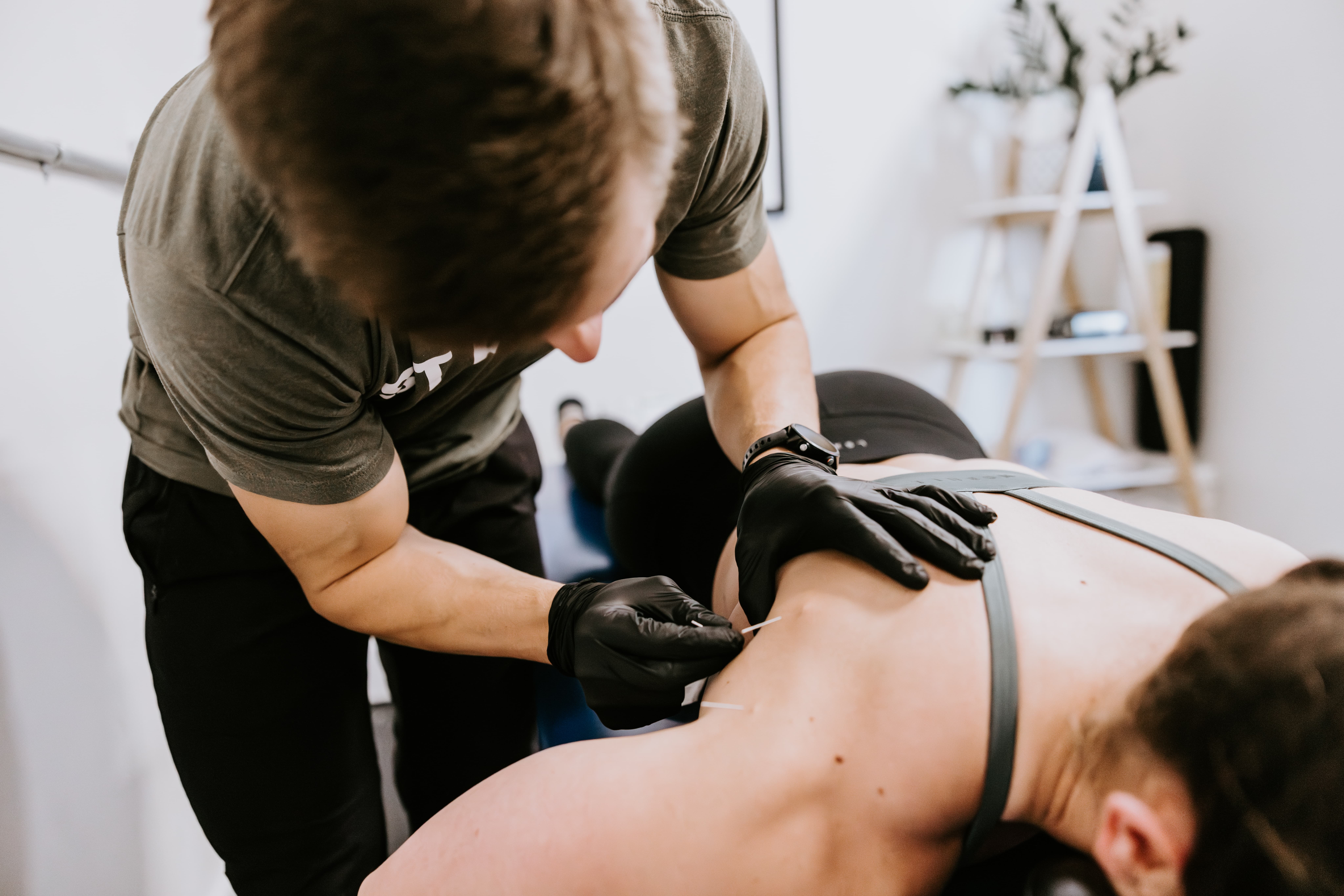 Dry needling performed by physical therapist on patients shoulder