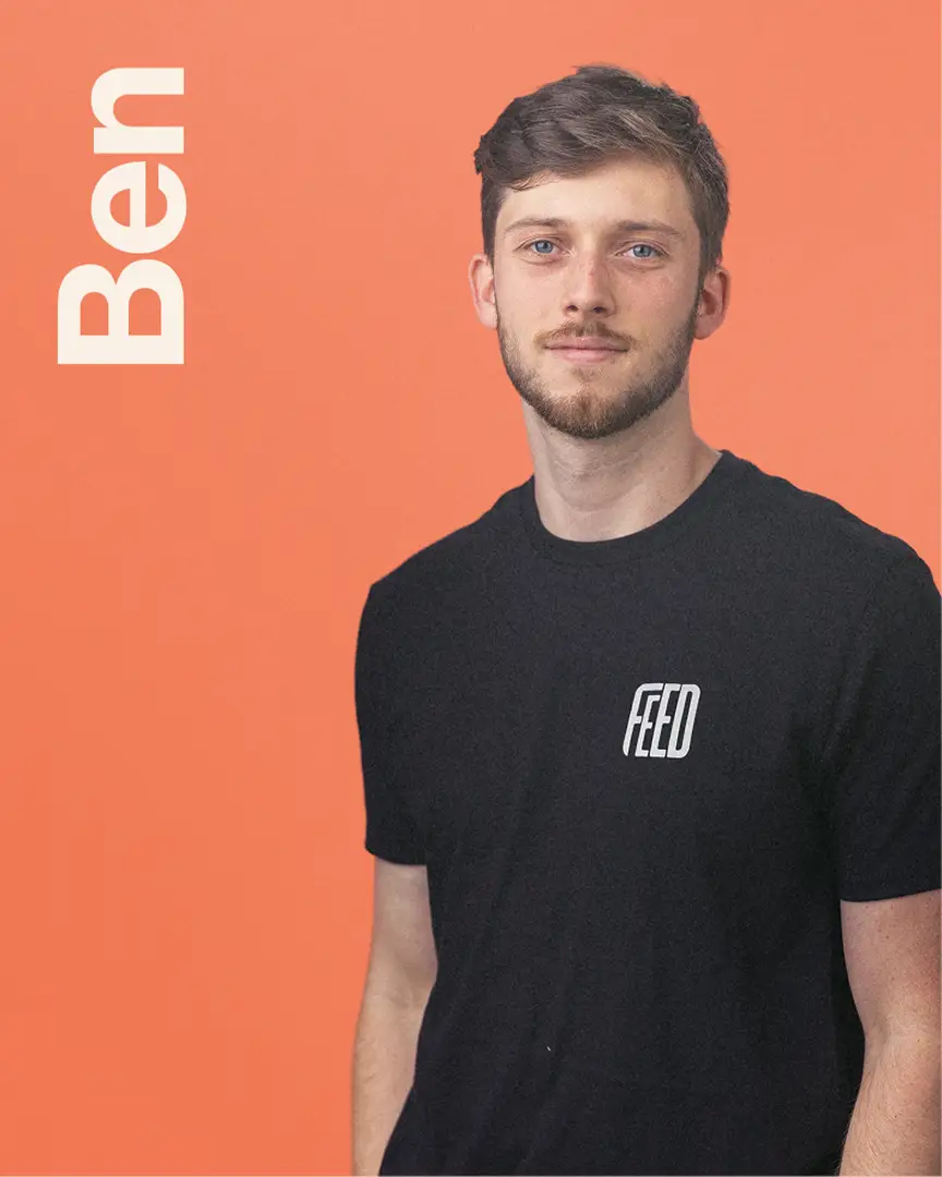 Ben wearing a black FEED t-shirt standing with the name Ben in vertical text.