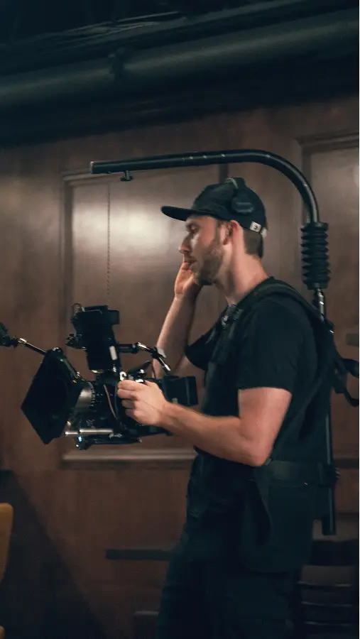 Ben operating a professional camera rig with stabilizer on set.