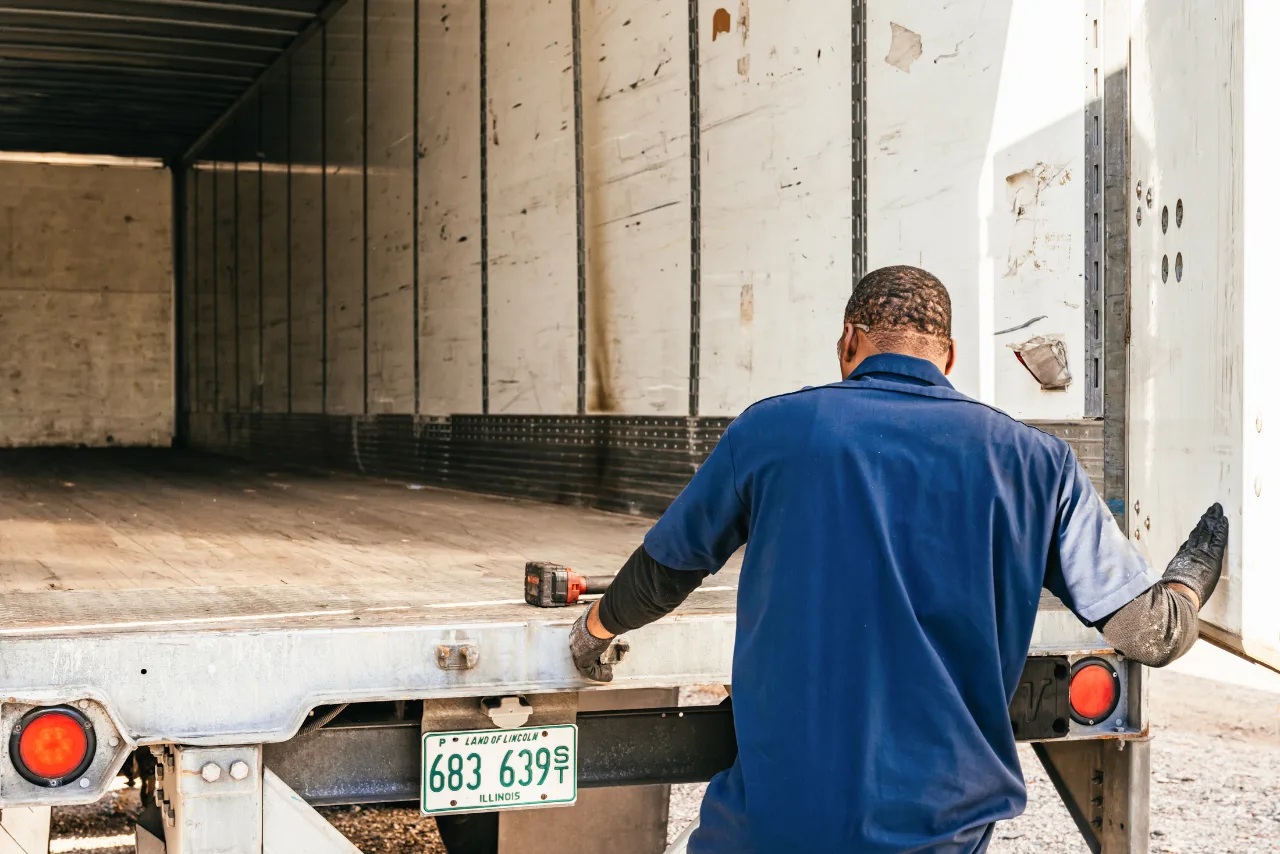 Technician inspecting an open semi-trailer during fall trailer maintenance in Central Arkansas to prepare for winter.