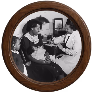 Black and white photo of a nurse in a white uniform consulting with a seated mother holding a baby, while a young girl stands nearby.
