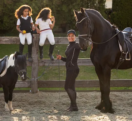 Instructor with children and horses reflecting youth outreach by South Florida Horsemen’s Group.