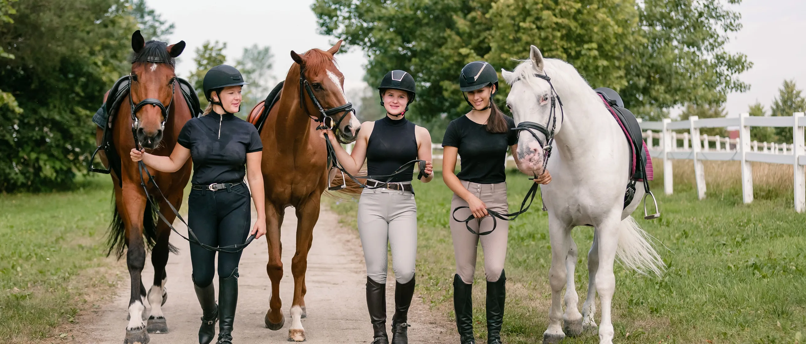 Equestrians walk horses along path representing South Florida Horsemen’s Group community.