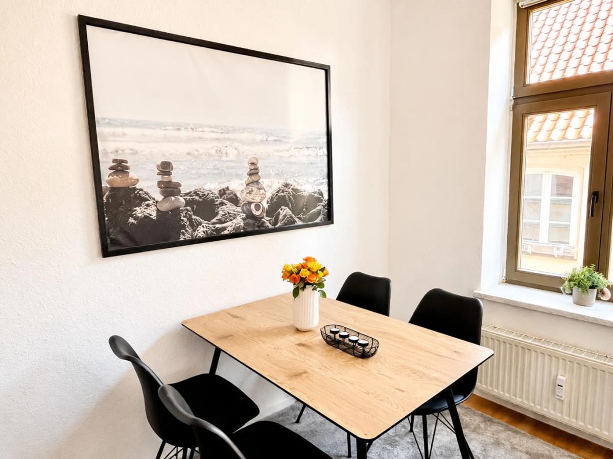 Heller Essbereich mit Holztisch und schwarzen Stühlen in einem Wismarer Apartment