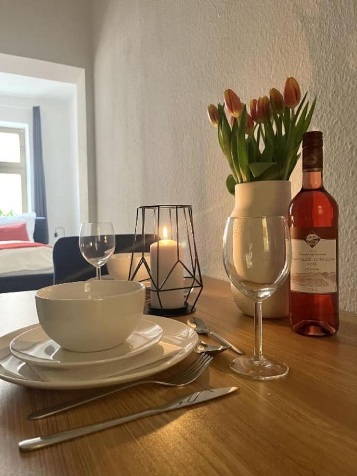 Nahaufnahme eines gedeckten Esstischs mit Weingläsern und Tulpen