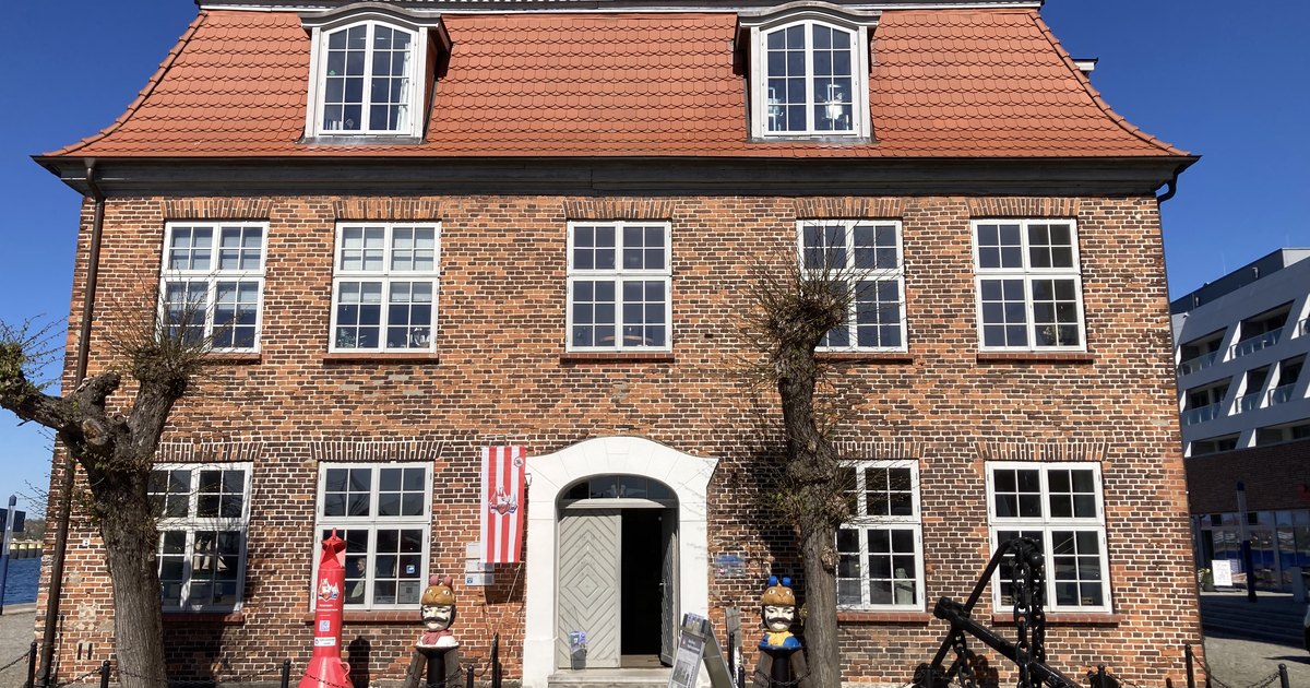 Backsteinbau des Baumhauses am Alten Hafen in Wismar mit den beiden Schwedenköpfen davor