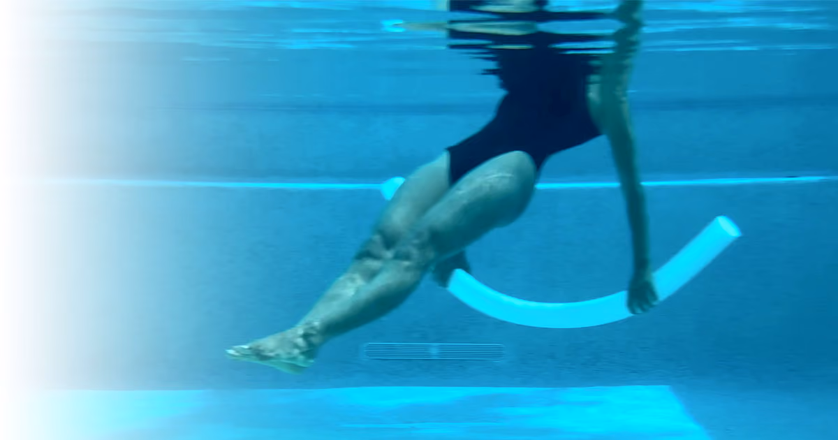 Woman performing Water Pilates exercise in a pool using a noodle for core strength and balance
