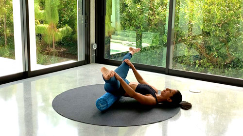 Foam roller side split stretch with legs opening outward