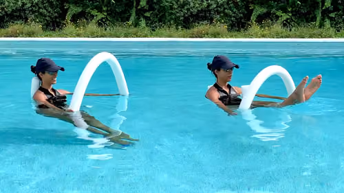 Woman performing a pool pilates teaser, lifting and lowering the legs with a noodle.