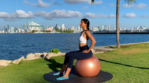 Forward pelvic tilt on a stability ball to stretch the lower back and hips