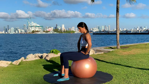Backward pelvic tilt on a stability ball engaging core and stretching the lower back