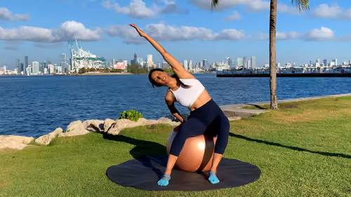 Side to side stretching exercise with a stability ball to improve flexibility and spinal mobility