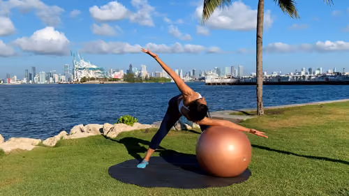 Standing spine rotation stretch with a stability ball to improve mobility and flexibility