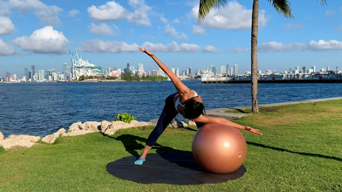 Standing spine rotation stretch with a stability ball to improve mobility and flexibility