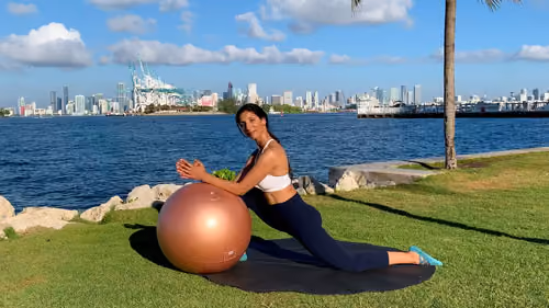 Supported hip flexor stretch with a stability ball in a kneeling lunge