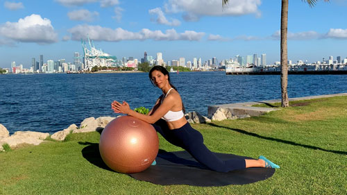 Supported hip flexor stretch with a stability ball in a kneeling lunge