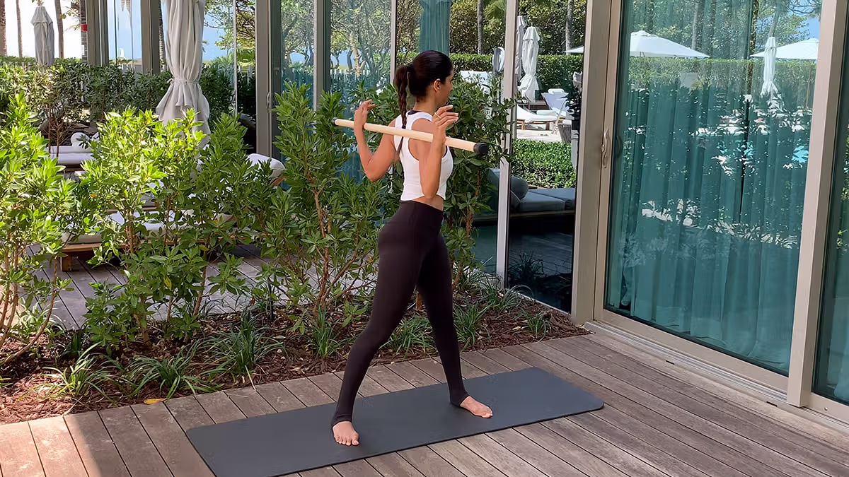 Standing torso twist using a mobility stick behind the shoulders to improve spinal rotation