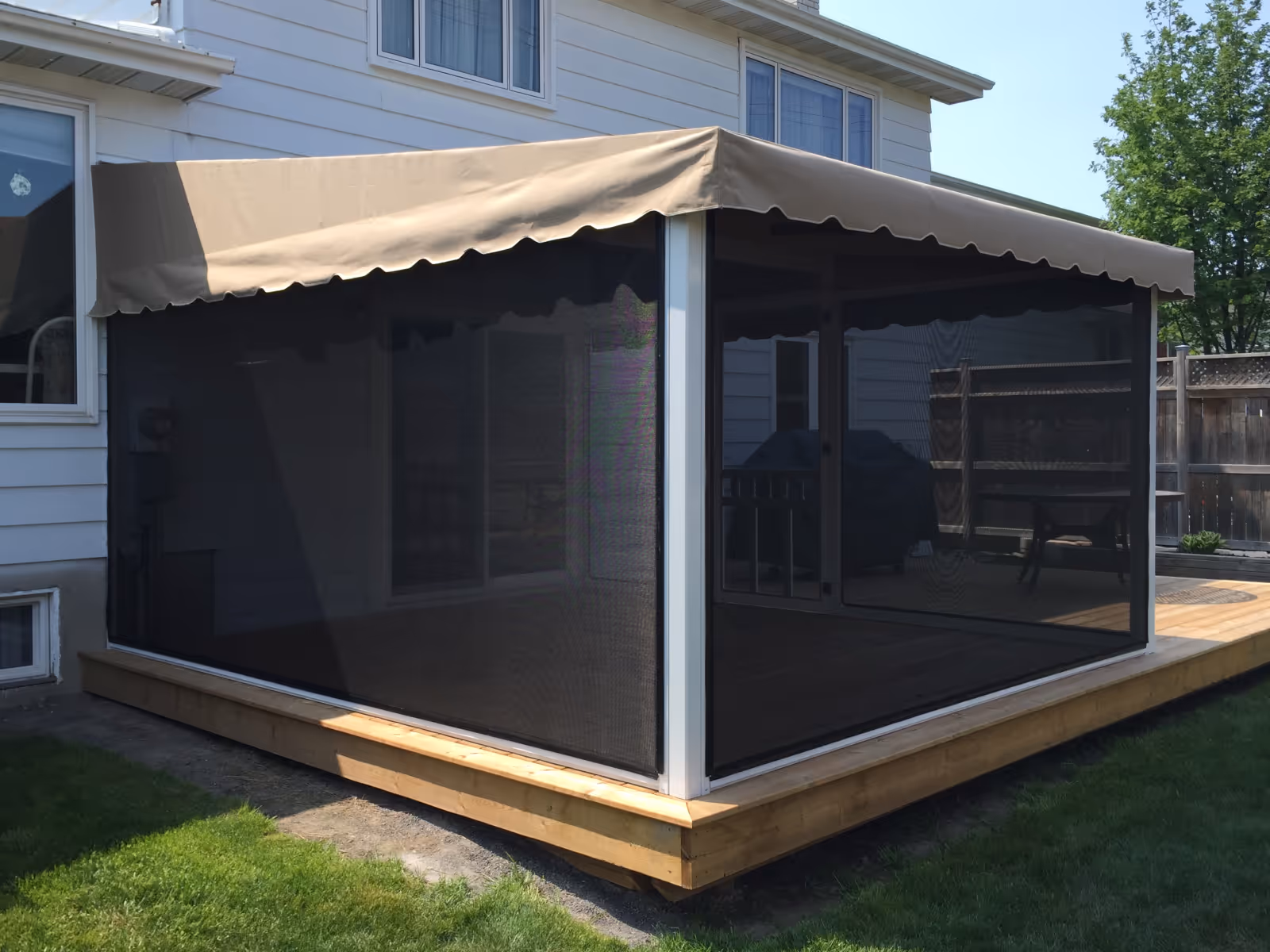 White awning with beige fabric cover and black tension screens on a wooden deck.