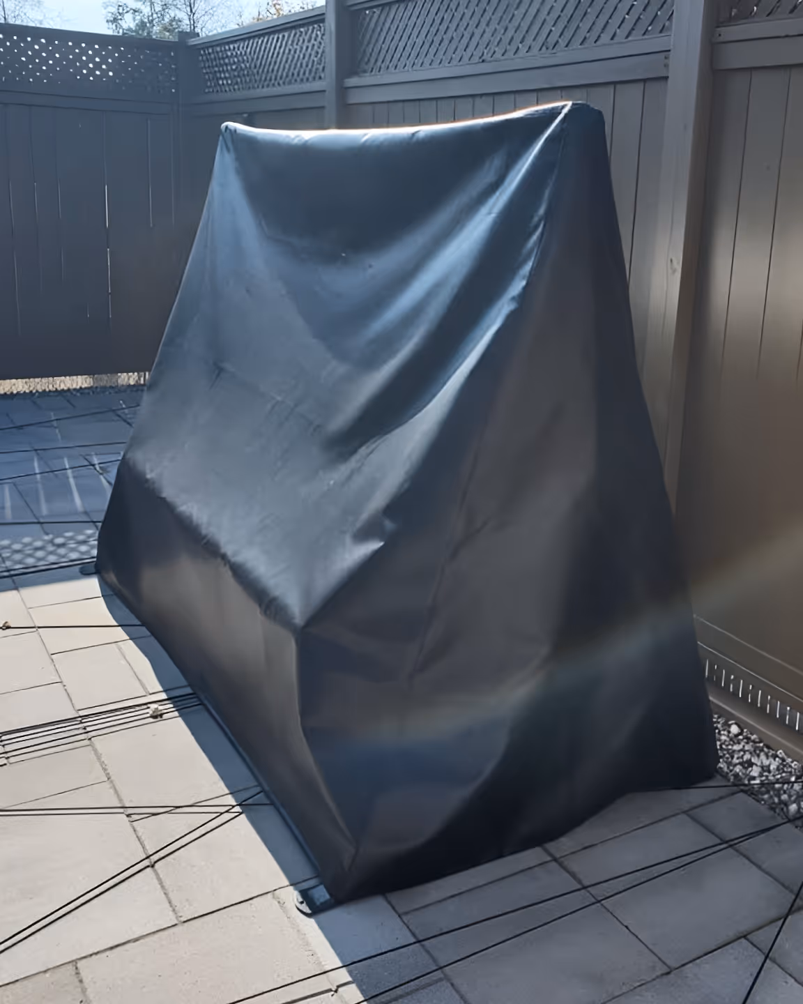 Outdoor furniture cover made of black vinyl fabric.