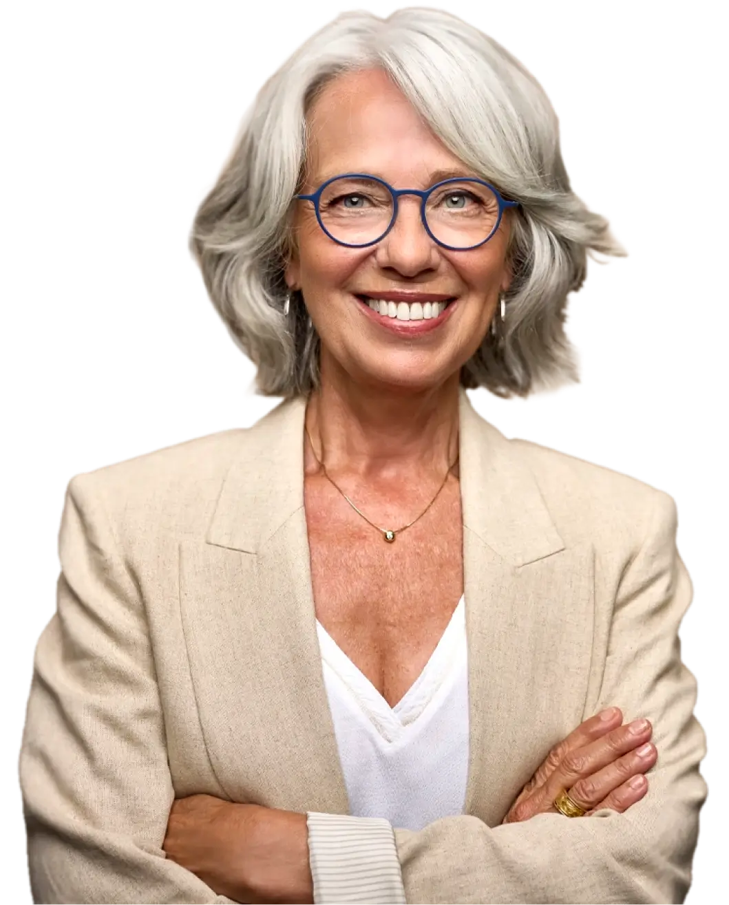 Smiling older woman with gray hair wearing blue round glasses, beige blazer, and white top with arms crossed.
