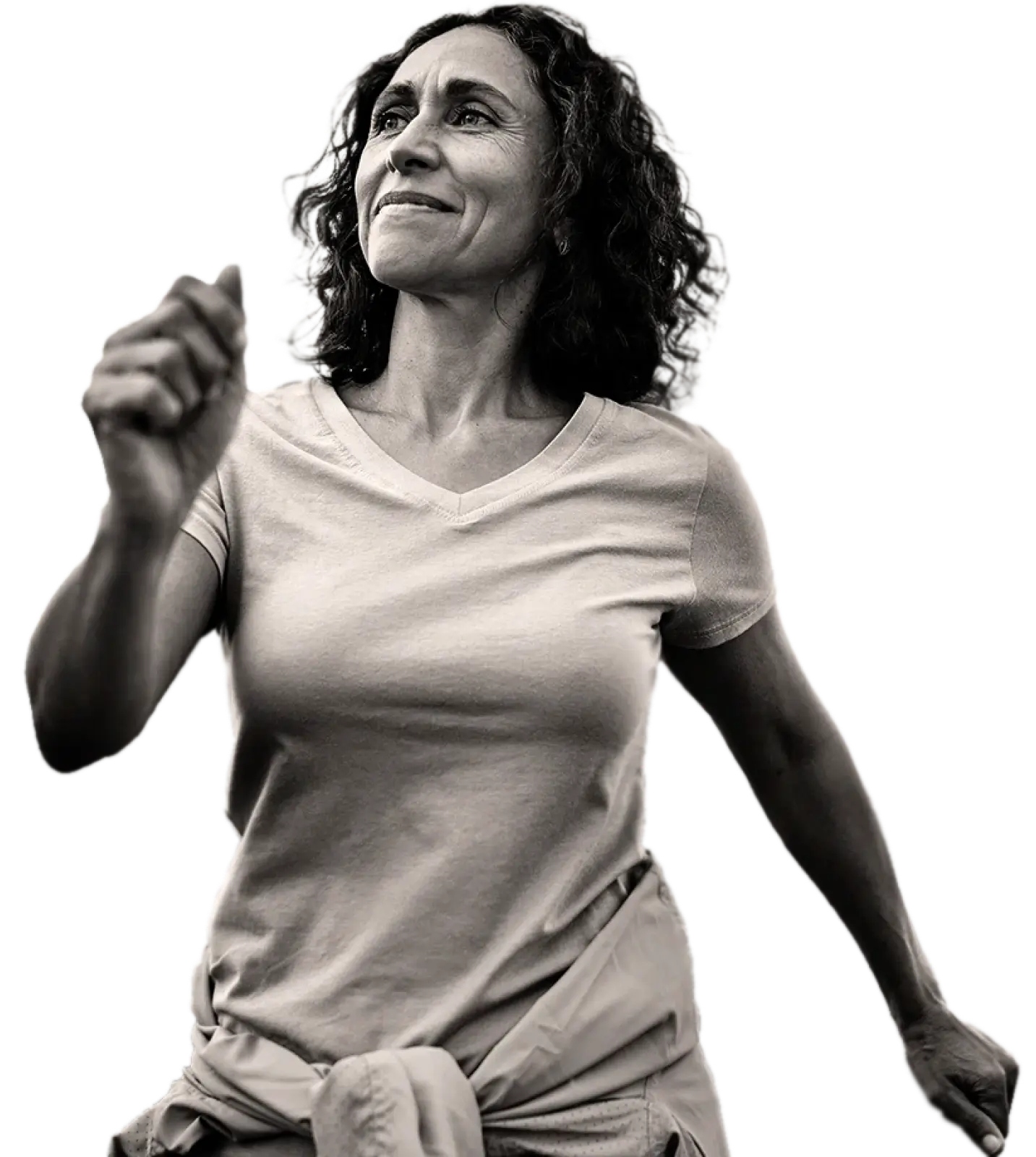 Middle-aged woman with curly hair in a light t-shirt walking confidently.