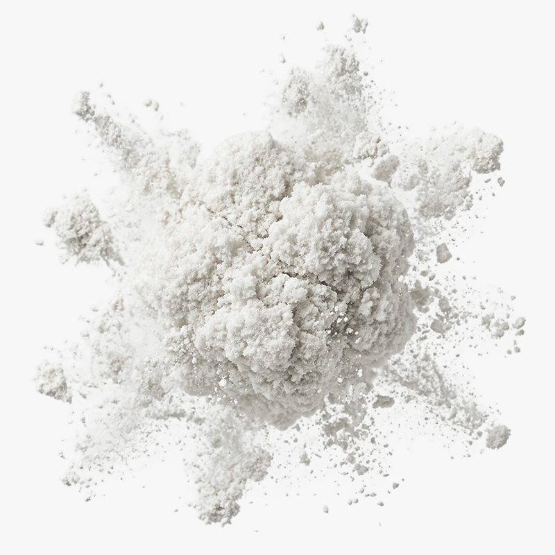 Close-up of a burst of fine white powder particles scattered in the air against a white background.