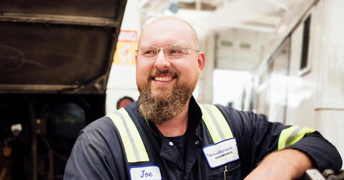 Community Transit maintenance mechanic standing beside vehicle in service bay