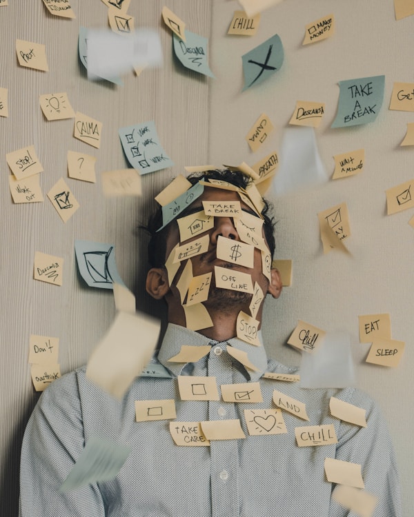 Young man covered in sticky notes, work overload