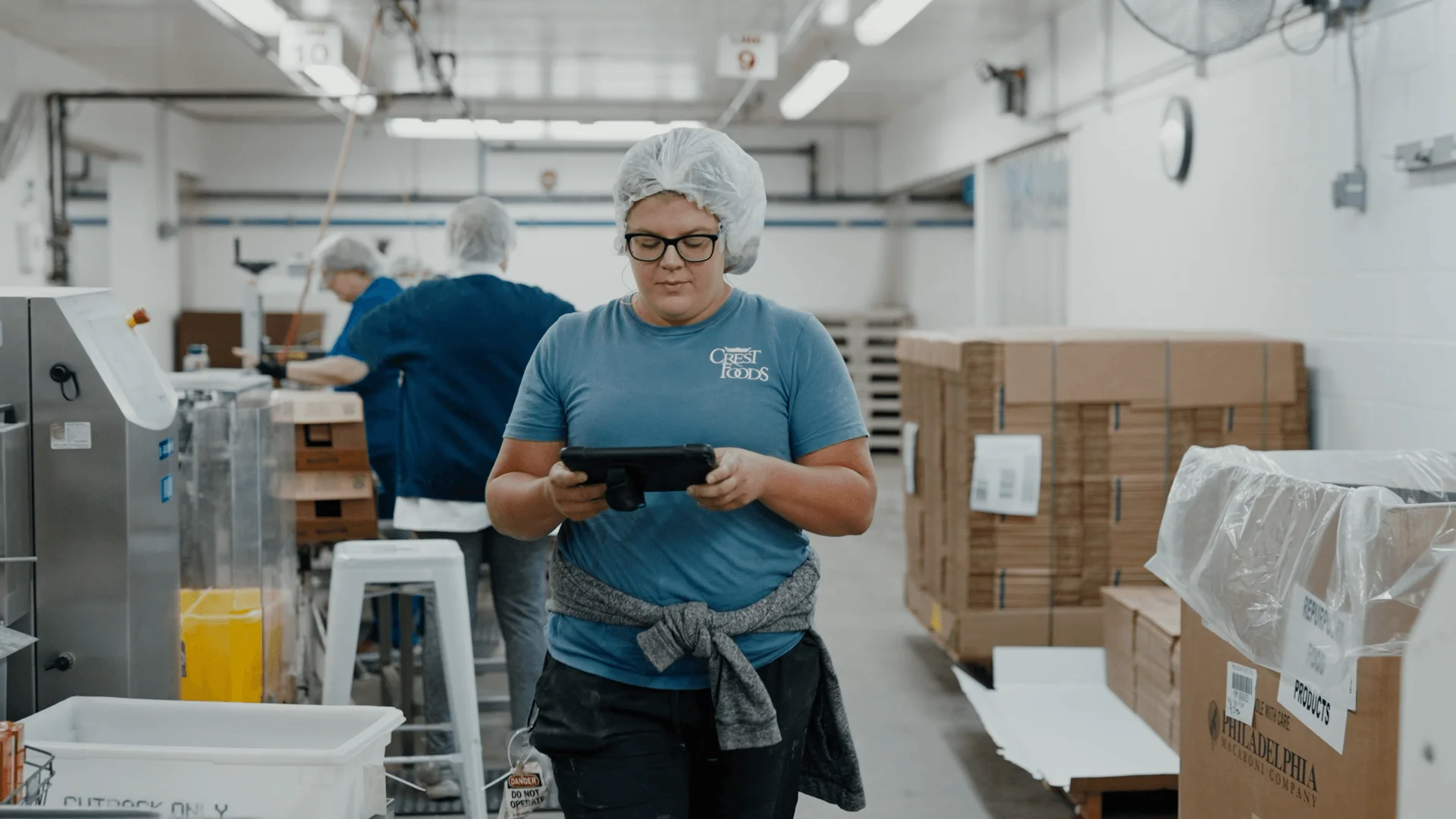 Manufacturing worker monitoring industrial machinery and production equipment in a large factory.