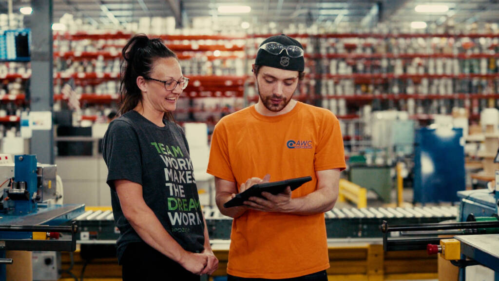 Fertigungsarbeiter überwacht Industriemaschinen und Produktionsanlagen in einer großen Fabrik.