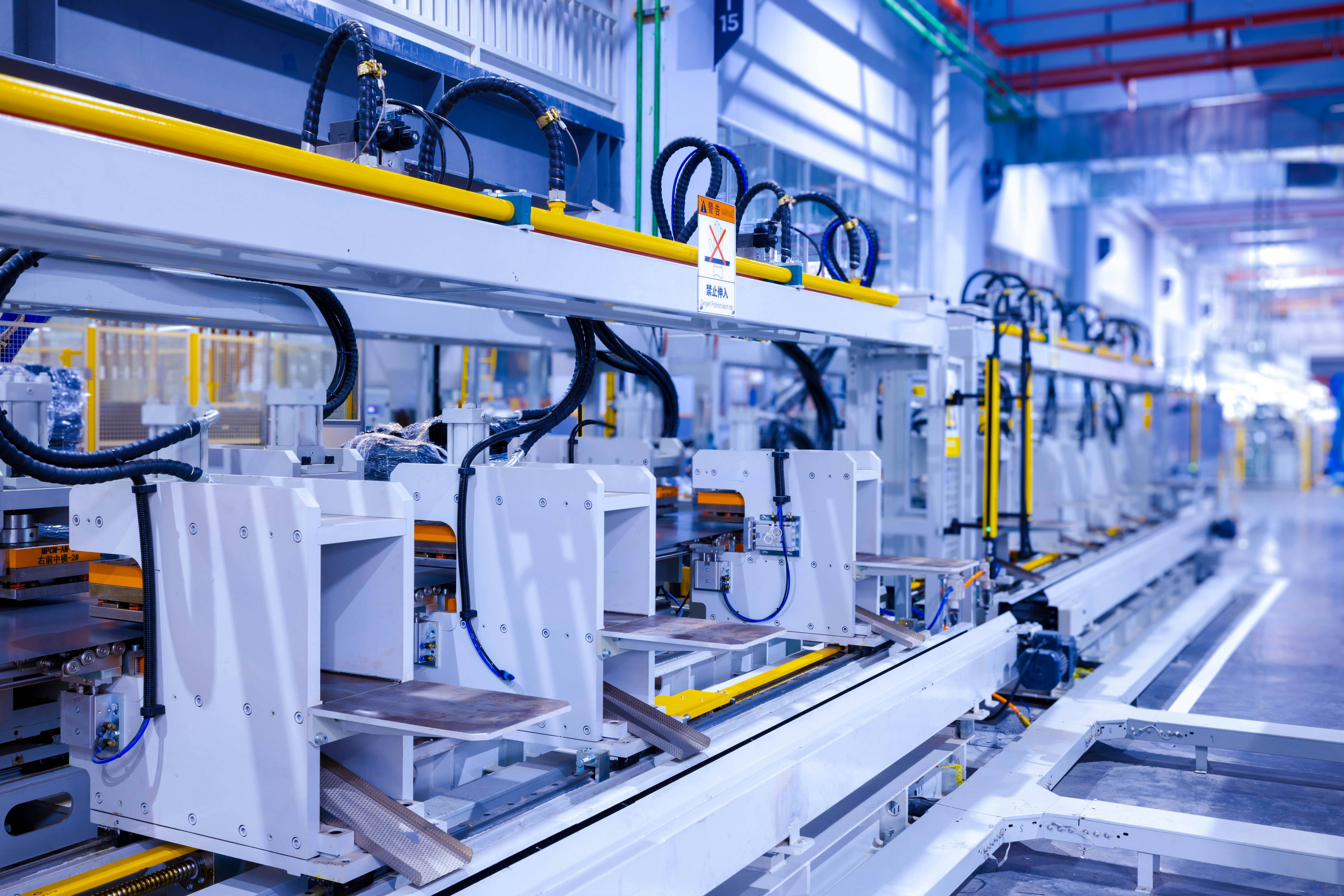 Industrial production line of a refrigerator manufacturing plant Translation: "WARNING Danger! Prohibit reach into"