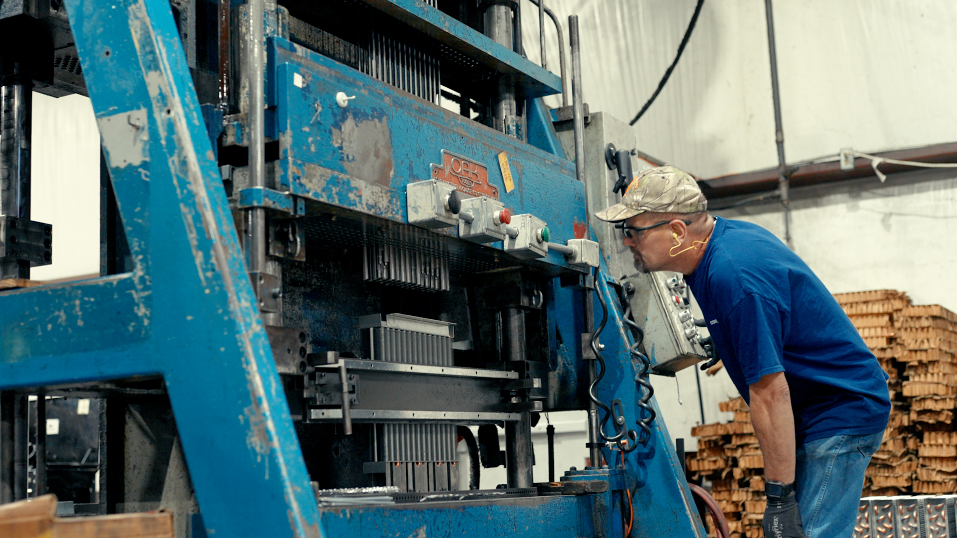 Factory worker reviews equipment in an plant setting.