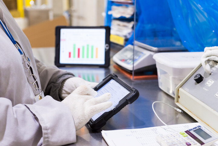 Worker with an iPad looking at quality dashboards.